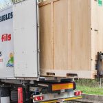 Transpalette chargeant un container à l'arrière d'un camion de déménagement pour gros volumes