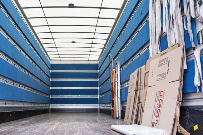 intérieur d'un camion avec sangles et cartons